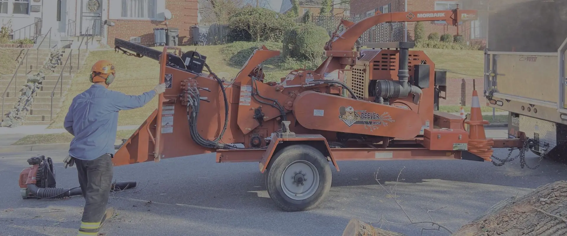 A large orange truck with a tree in the back.