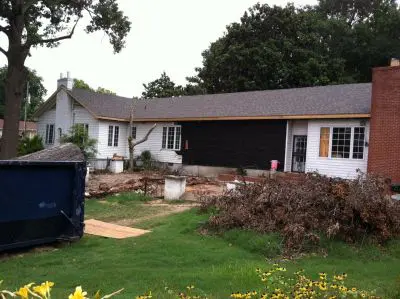 A house that is being remodeled with trees in the background.