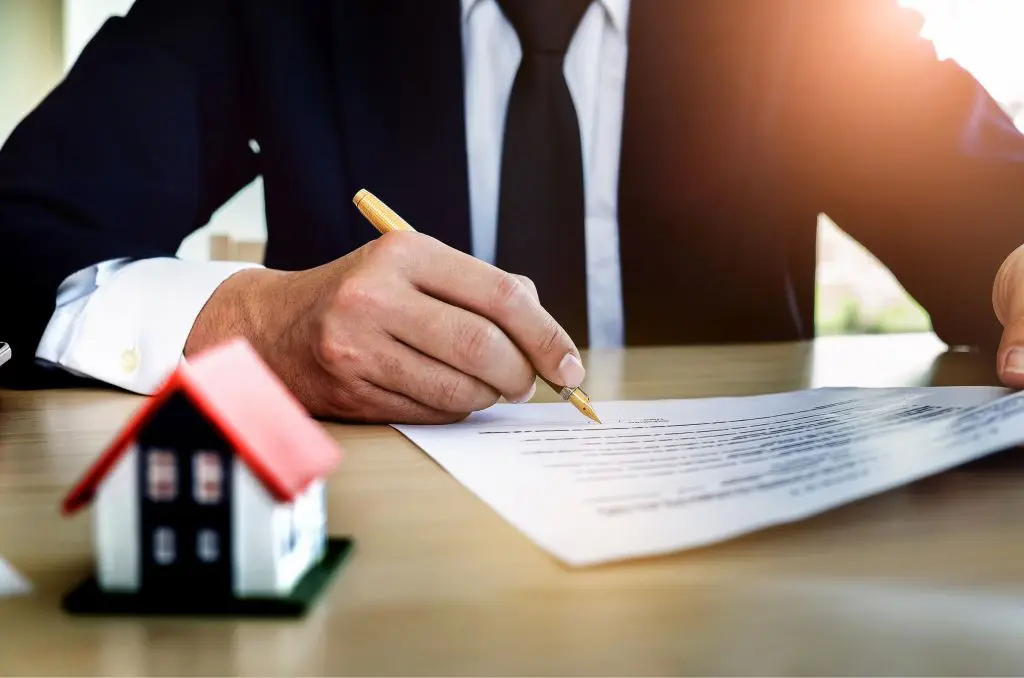 A man in a suit is writing on paper.