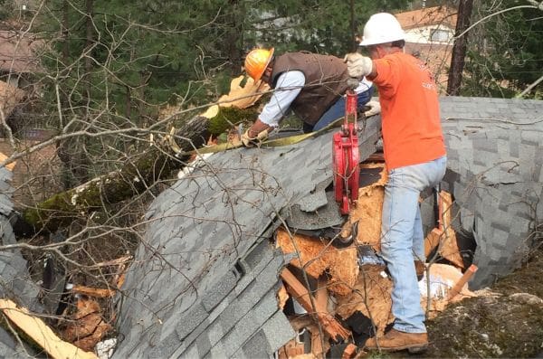 Two men working on a roof of a house.